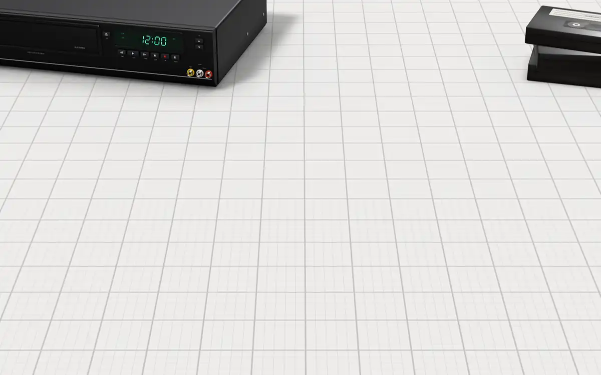 Illustration of the 5 VHS to digital converters to scale, next to a VCR blinking 12:00 and a stack of home-video tapes for size